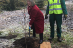 Fiona Bruce digging a hole for a tree sapling with a gentleman in a high vis jacket