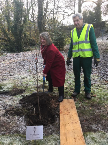 Fiona Bruce digging a hole for a tree sapling with a gentleman in a high vis jacket