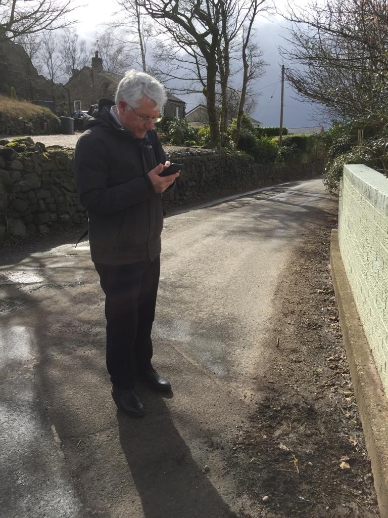 Patrick Redstone on the telephone on a road in Mow Cop