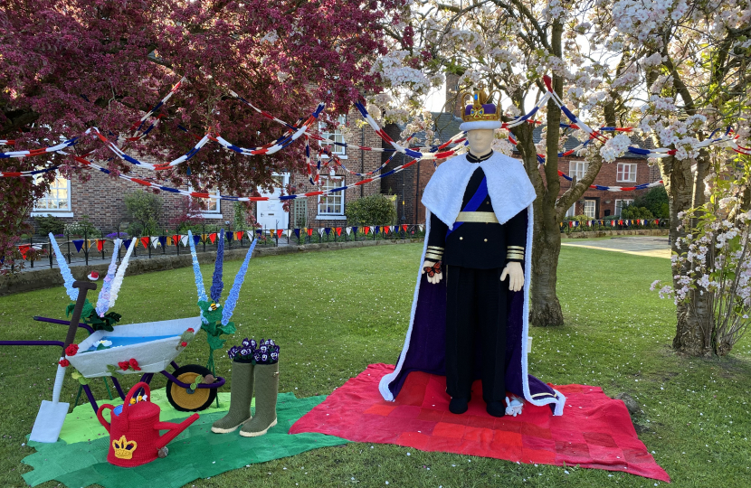 A lifesize knitted King Charles III and gardening equipment