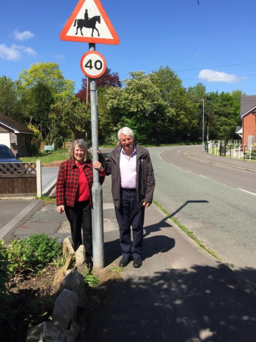 Fiona Bruce MP and Cllr Patrick Redstone by a road warning sign